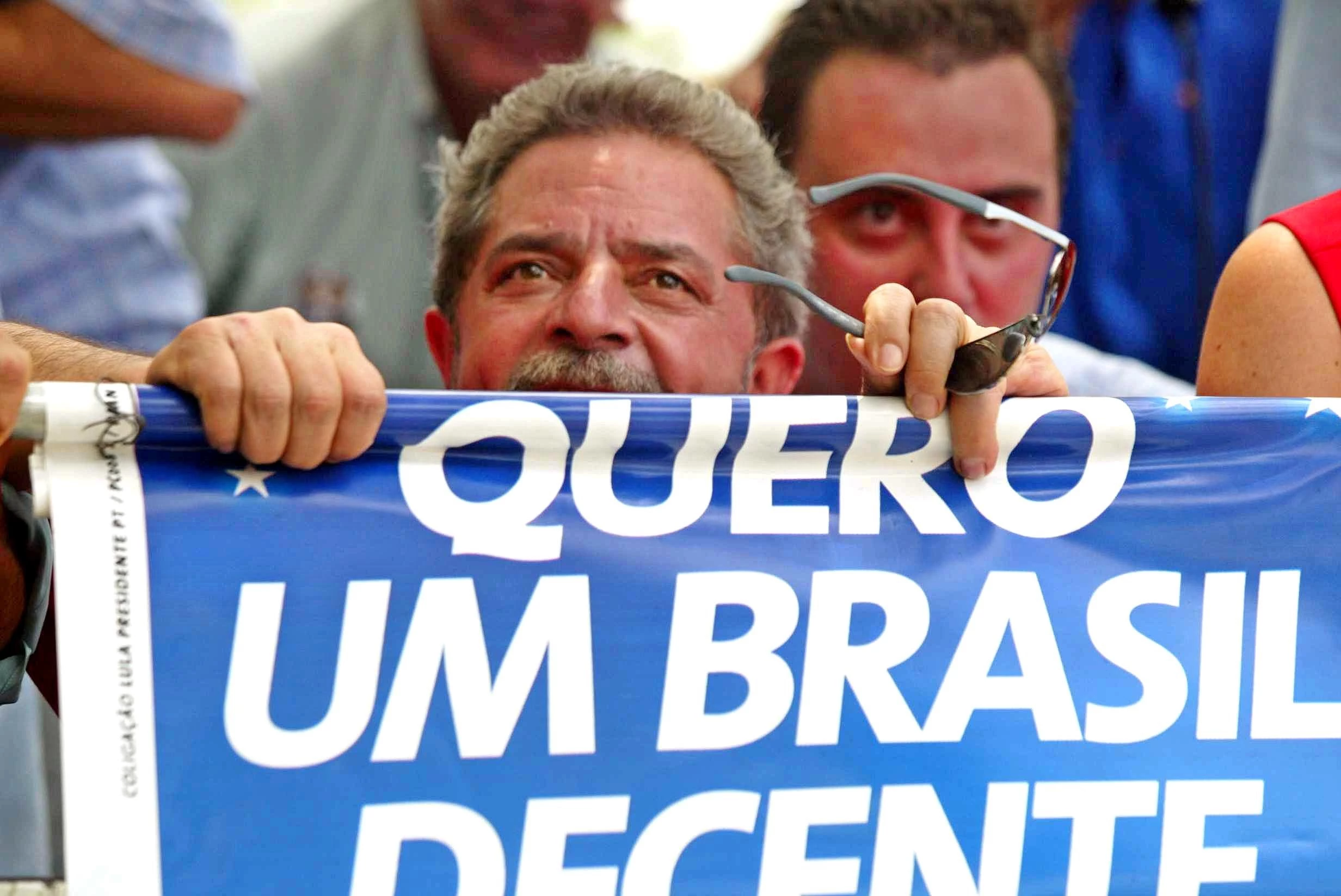 Eleições 2002: o candidato do PT à Presidência da República, Luiz Inácio Lula da Silva, abaixado para se proteger dos fios da eletricidade durante carreata do PT na zona sul de São Paulo (SP). (São Paulo, SP, 20.10.2002. 12h. Foto: Juca Varella /Folhapress. Digital)