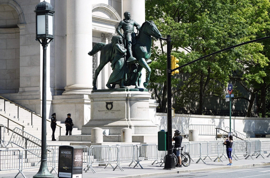 Pessoas passam pela estátua equestre de Theodore Roosevelt em frente ao Museu Americano de História Natural, em 22 de junho, na cidade de Nova York.
