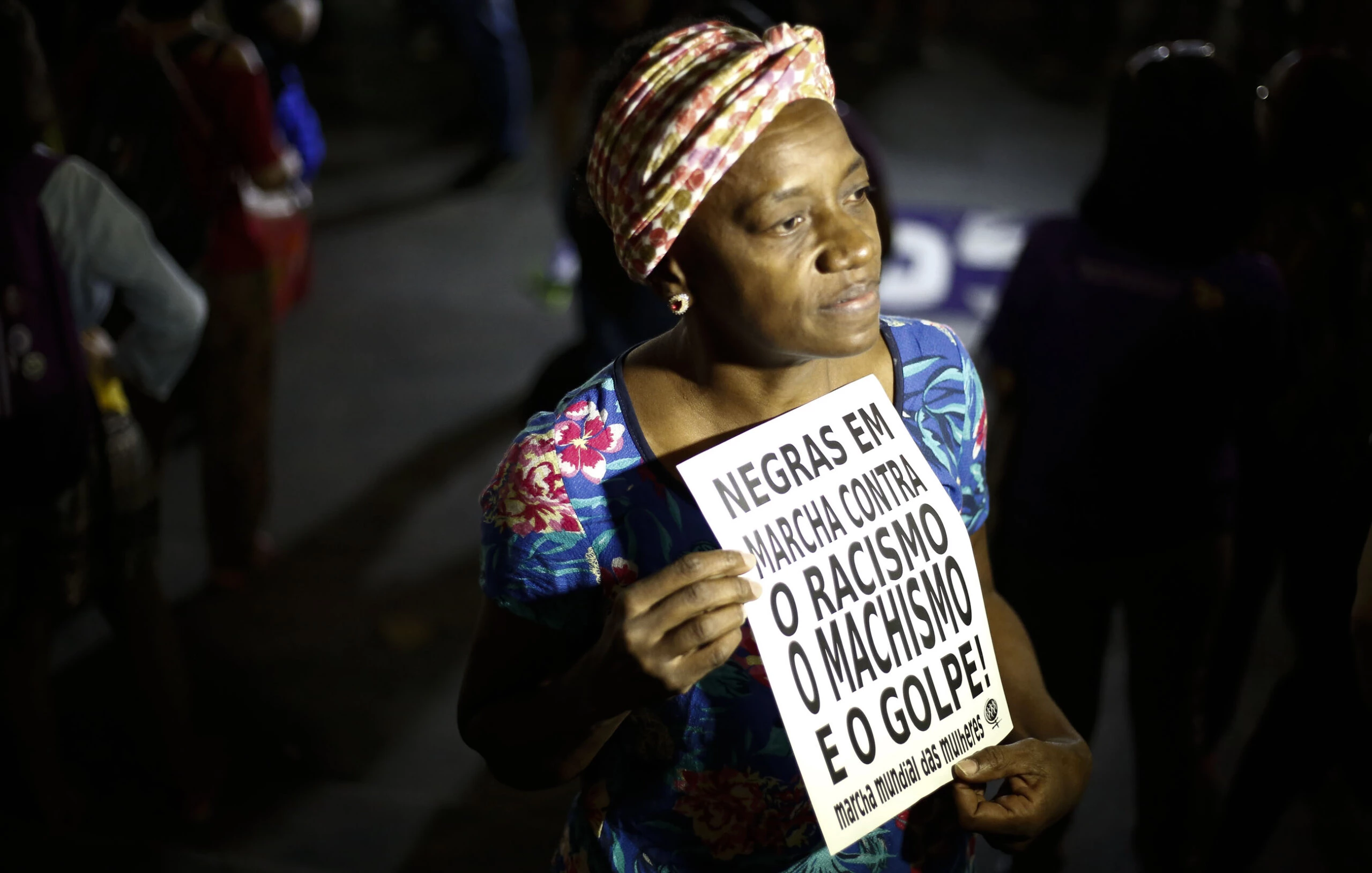 A woman holds a sign reading "Black women march against racism, male chauvinism and the coup" during a protest against the president of the Brazilian lower house Eduardo Cunha, Brazilian Vice-President Michel Temer and Jair Bolsonaro -a far right member of Congress who has praised Brazil's former military dictatorship and torture of opponents in the 1970s- in Sao Paulo, Brazil on April 26, 2016. Six out of 10 Brazilians want snap elections to resolve the country's political crisis in which leftist President Dilma Rousseff faces impeachment, a poll released Tuesday said. / AFP / Miguel Schincariol (Photo credit should read MIGUEL SCHINCARIOL/AFP/Getty Images)