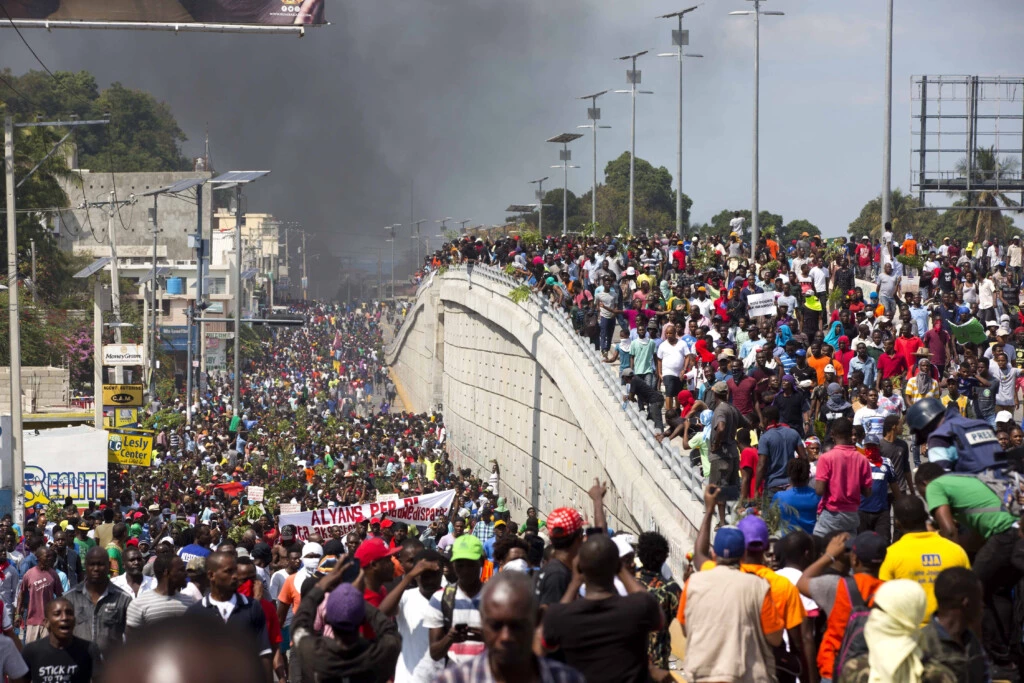 Milhares de manifestantes marcham nas ruas durante protesto para exigir a renúncia do presidente Jovenel Moïse em 7 de fevereiro.
