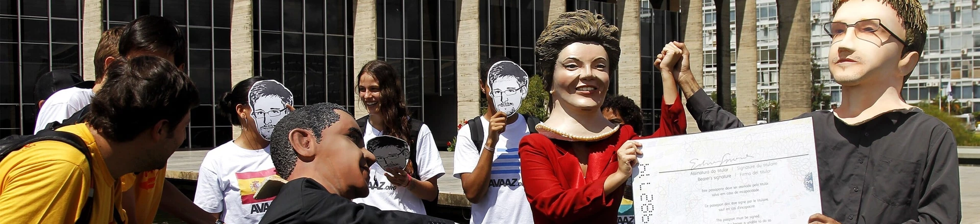 Members of the Avaaz online community organization stage in front of the Itamaraty Forein Ministry Palace the delivery of the Brazilian passport by Brazilian President Dilma Rousseff to Edward Snowden while U.S. President Barack Obama tries to stop her, in Brasilia, on February 13, 2014. Avaaz members have collected over a million signatures in favor of the asylum application for Snowden, the former CIA technician that disclosed the spying by the U.S. government to millions of people, among whom President Rousseff and German Chancellor Angela Merkel. AFP PHOTO/Beto BARATA (Photo credit should read BETO BARATA/AFP/Getty Images) Members of the Avaaz online community organization stage in front of the Itamaraty Forein Ministry Palace the delivery of the Brazilian passport by Brazilian President Dilma Rousseff to Edward Snowden while U.S. President Barack Obama tries to stop her, in Brasilia, on February 13, 2014. Avaaz members have collected over a million signatures in favor of the asylum application for Snowden, the former CIA technician that disclosed the spying by the U.S. government to millions of people, among whom President Rousseff and German Chancellor Angela Merkel. AFP PHOTO/Beto BARATA (Photo credit should read BETO BARATA/AFP/Getty Images)