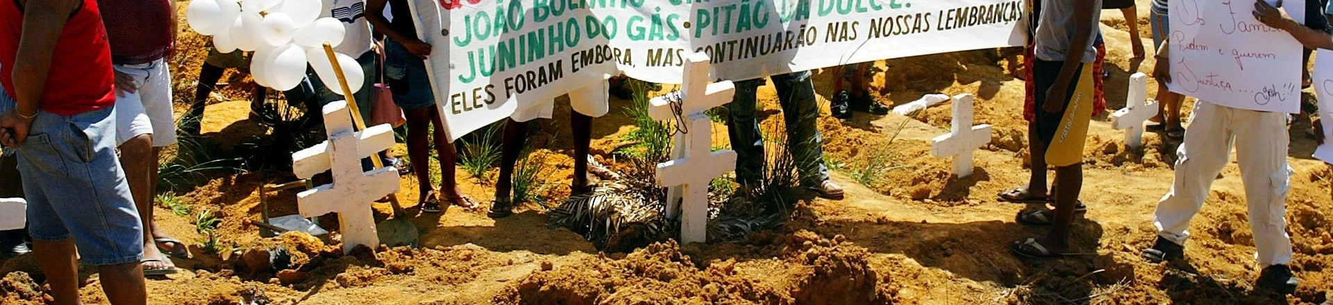 Massacre na Baixada Fluminense: parentes exibem faixa, no cemitério da Jaqueira, em Queimados, pedindo justiça durante enterro de vítimas da chacina que deixou 30 mortos nas cidades de Queimados e Nova Iguaçu, na Baixada Fluminense, no Rio de Janeiro. (Queimados (RJ), 02.04.2005. Foto de Ana Carolina Fernandes/Folhapress) Massacre na Baixada Fluminense: parentes exibem faixa, no cemitério da Jaqueira, em Queimados, pedindo justiça durante enterro de vítimas da chacina que deixou 30 mortos nas cidades de Queimados e Nova Iguaçu, na Baixada Fluminense, no Rio de Janeiro. (Queimados (RJ), 02.04.2005. Foto de Ana Carolina Fernandes/Folhapress)