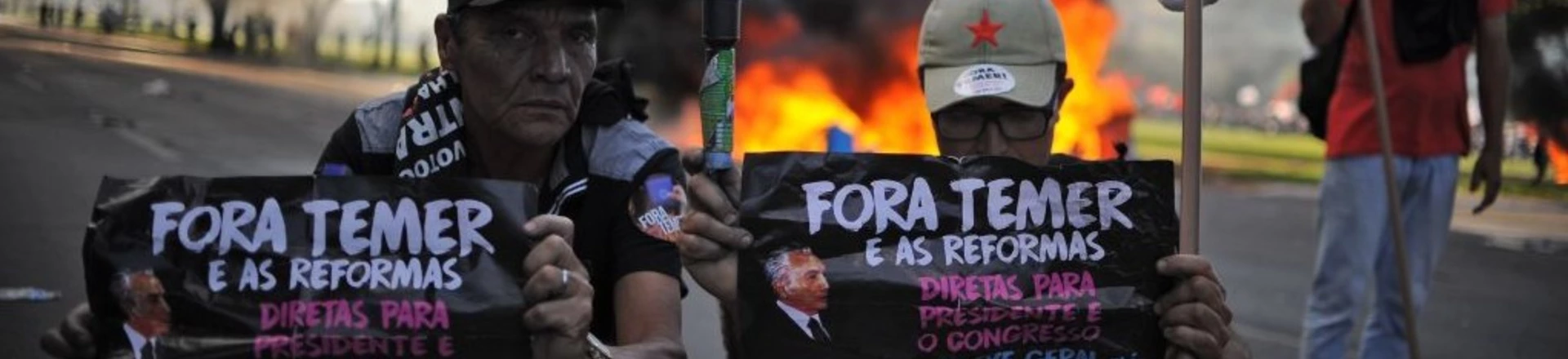 Demonstrators hold banners against Brazilian President Michel temer during clashes in the protest "Occupy Brasilia" against the labor and social security reforms of his government in Brasilia, on May 24, 2017. / AFP PHOTO / Andressa Anholete (Photo credit should read ANDRESSA ANHOLETE/AFP/Getty Images) Demonstrators hold banners against Brazilian President Michel temer during clashes in the protest "Occupy Brasilia" against the labor and social security reforms of his government in Brasilia, on May 24, 2017. / AFP PHOTO / Andressa Anholete (Photo credit should read ANDRESSA ANHOLETE/AFP/Getty Images)