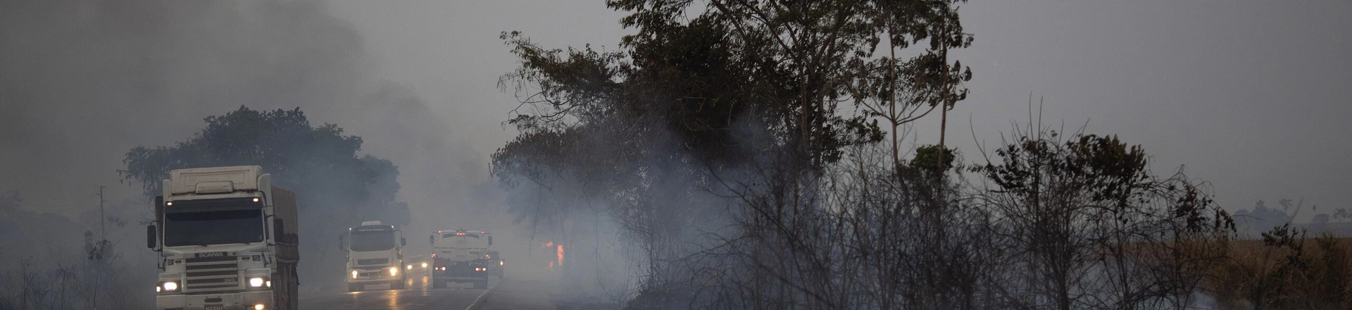 Caminhões dirigem ao lado de campos queimados na rodovia BR-163, no estado do Mato Grosso, em 23 de agosto de 2019. Caminhões dirigem ao lado de campos queimados na rodovia BR-163, no estado do Mato Grosso, em 23 de agosto de 2019.