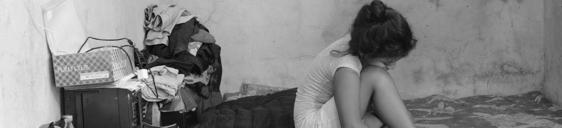 Migrante de 10 anos, que fugiu de ameaças de gangues de El Salvador, senta-se sobre os lençóis que sua família usa como cama em uma casa alugada em Tapachula, Chiapas. Migrante de 10 anos, que fugiu de ameaças de gangues de El Salvador, senta-se sobre os lençóis que sua família usa como cama em uma casa alugada em Tapachula, Chiapas.