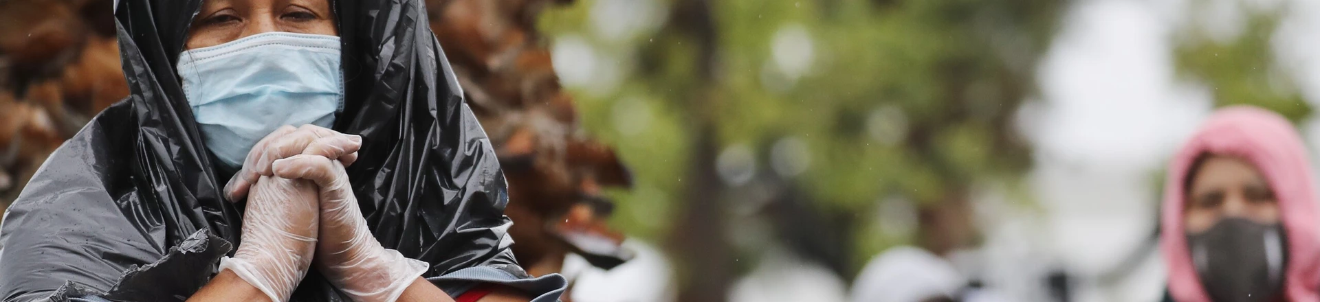 Juana Gomez, à esquerda, usa máscara, luvas, e um saco de lixo para se proteger da chuva na fila de espera em um centro de distribuição de alimentos durante a pandemia do coronavírus, no dia 9 de abril de 2020, em Van Nuys, na Califórnia. Juana Gomez, à esquerda, usa máscara, luvas, e um saco de lixo para se proteger da chuva na fila de espera em um centro de distribuição de alimentos durante a pandemia do coronavírus, no dia 9 de abril de 2020, em Van Nuys, na Califórnia.