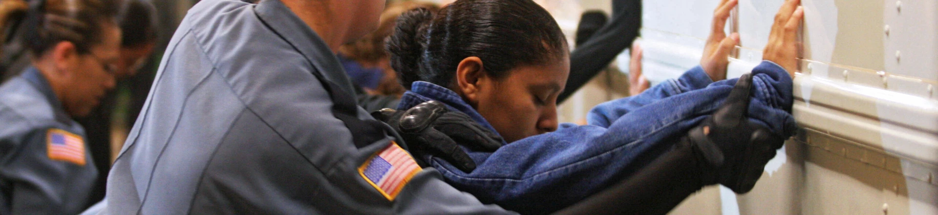 TO GO WITH AFP STORY BY CARLOS MARIO MARQUEZ A prison guard frisks a female detainee before embarking onto a bus to be taken to the airport at Willacy Detention facility in Raymondville, Texas on December 18, 2008 early morning. The Willacy facility is used by the US Immigration and Customs Enforcement agency (ICE) to keep illegal immigrants in detention before they are deported. Today, 116 Salvadorean nationals --83 men and 33 women-- were woken up at 4 a.m. and transported in buses under strict surveillance to Harlengen's airport to be taken back to El Salvador. AFP PHOTO/ Jose CABEZAS (Photo credit should read Jose CABEZAS/AFP/Getty Images) TO GO WITH AFP STORY BY CARLOS MARIO MARQUEZ A prison guard frisks a female detainee before embarking onto a bus to be taken to the airport at Willacy Detention facility in Raymondville, Texas on December 18, 2008 early morning. The Willacy facility is used by the US Immigration and Customs Enforcement agency (ICE) to keep illegal immigrants in detention before they are deported. Today, 116 Salvadorean nationals --83 men and 33 women-- were woken up at 4 a.m. and transported in buses under strict surveillance to Harlengen's airport to be taken back to El Salvador. AFP PHOTO/ Jose CABEZAS (Photo credit should read Jose CABEZAS/AFP/Getty Images)