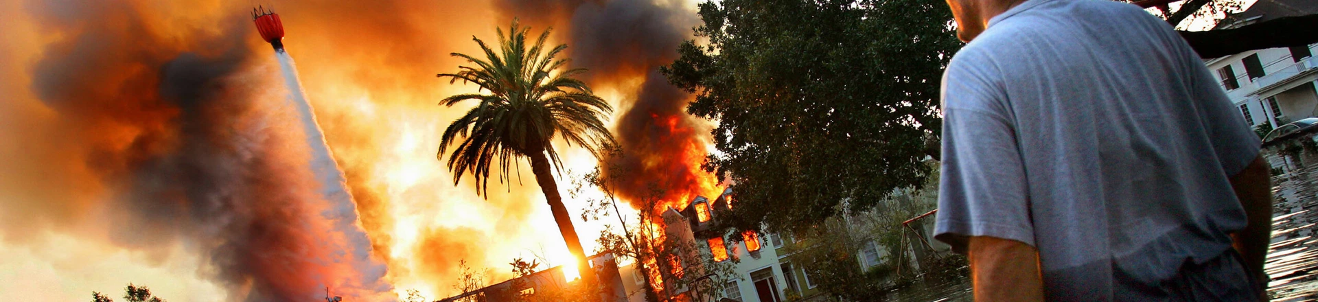 UNITED STATES - SEPTEMBER 04: A man watches a house burn on Napolean St. as helicopters try to extinguish the fire by dropping water from above in Hurricane Katrina ravaged New Orleans. Because of the extensive flooding caused by the breaking of the city's levies, fire trucks were unable to reach burning homes and in some cases whole blocks burned to the ground. (Photo by Craig Warga/NY Daily News Archive via Getty Images) UNITED STATES - SEPTEMBER 04: A man watches a house burn on Napolean St. as helicopters try to extinguish the fire by dropping water from above in Hurricane Katrina ravaged New Orleans. Because of the extensive flooding caused by the breaking of the city's levies, fire trucks were unable to reach burning homes and in some cases whole blocks burned to the ground. (Photo by Craig Warga/NY Daily News Archive via Getty Images)